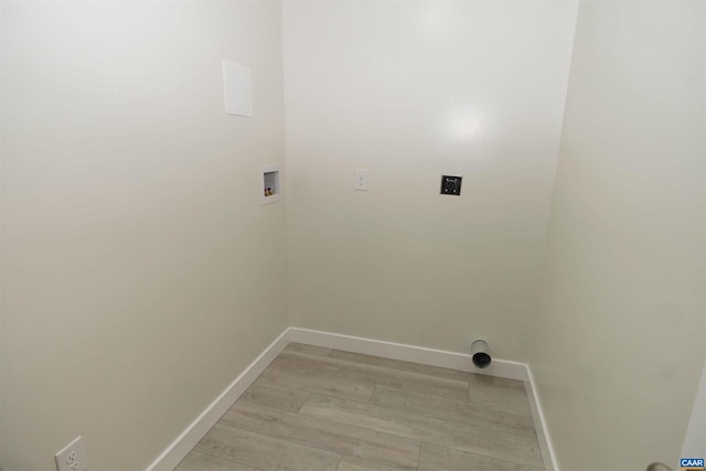 washroom with baseboards, light wood-style floors, washer hookup, and laundry area