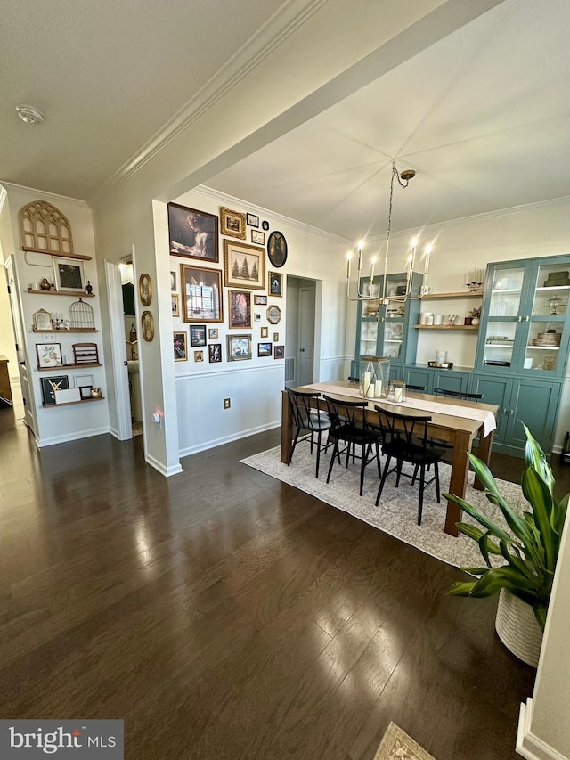 dining space with dark wood finished floors, crown molding, baseboards, and an inviting chandelier