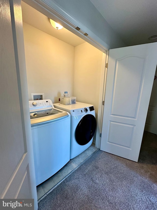 laundry room with washer and dryer, laundry area, dark tile patterned flooring, and dark colored carpet