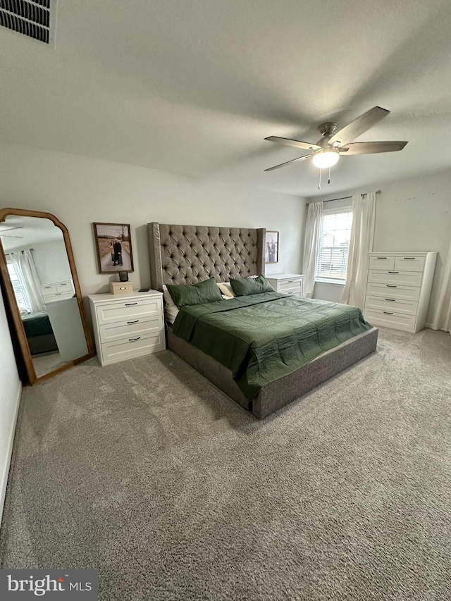 carpeted bedroom featuring visible vents and ceiling fan