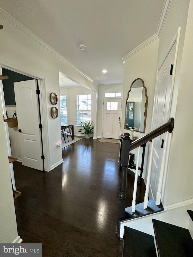 entryway with stairway, baseboards, wood finished floors, and crown molding