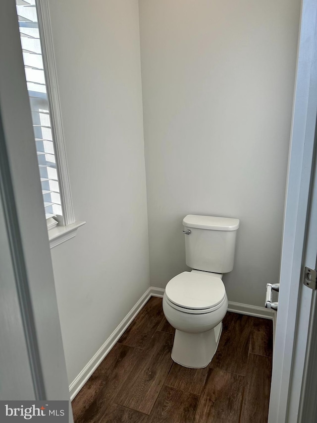 bathroom featuring baseboards, toilet, and wood finished floors