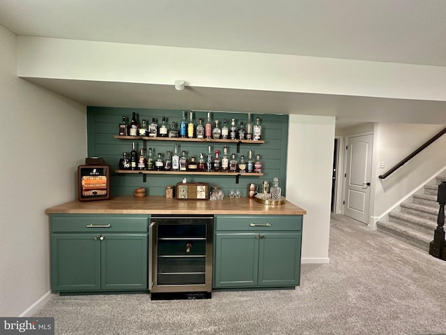 bar featuring light carpet, beverage cooler, stairway, baseboards, and a dry bar