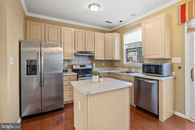 kitchen with light brown cabinetry, appliances with stainless steel finishes, under cabinet range hood, and a sink