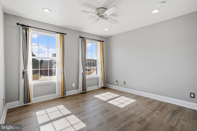 empty room featuring baseboards, ceiling fan, and wood finished floors