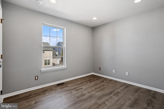 spare room with visible vents, recessed lighting, dark wood-type flooring, and baseboards