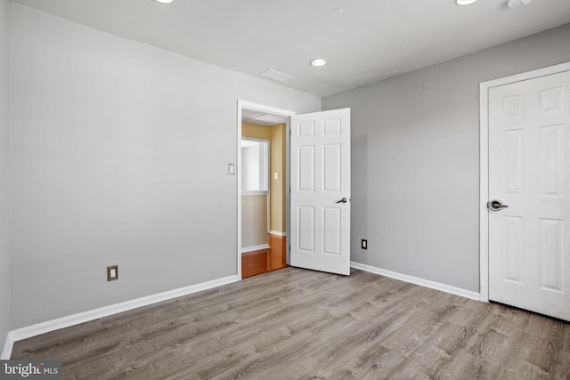 unfurnished bedroom featuring visible vents, recessed lighting, wood finished floors, and baseboards