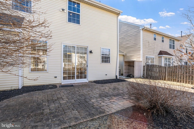 back of property featuring fence and a patio area