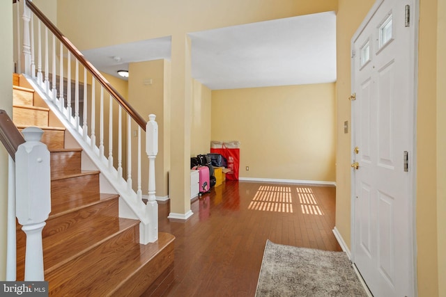 foyer with stairway, baseboards, and hardwood / wood-style flooring