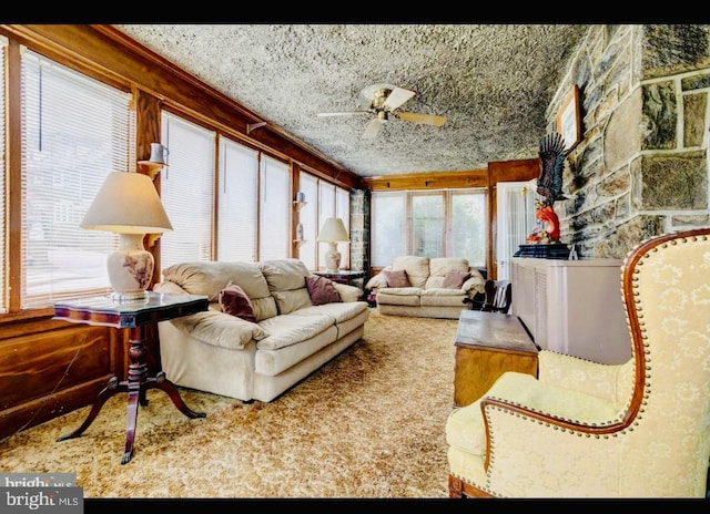 living area featuring a textured ceiling, plenty of natural light, and ceiling fan