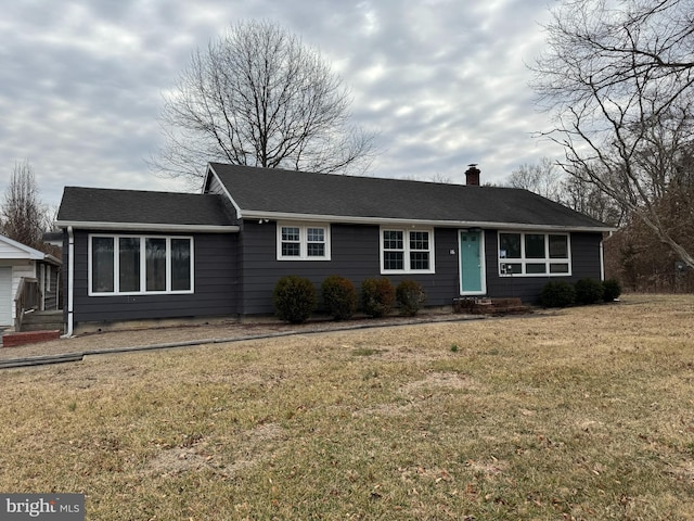 ranch-style house with a front lawn, roof with shingles, and a chimney