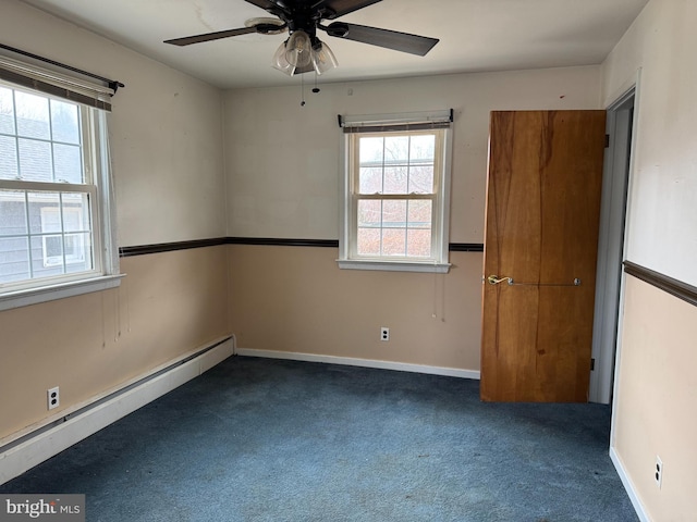 carpeted empty room featuring plenty of natural light, a ceiling fan, baseboards, and baseboard heating