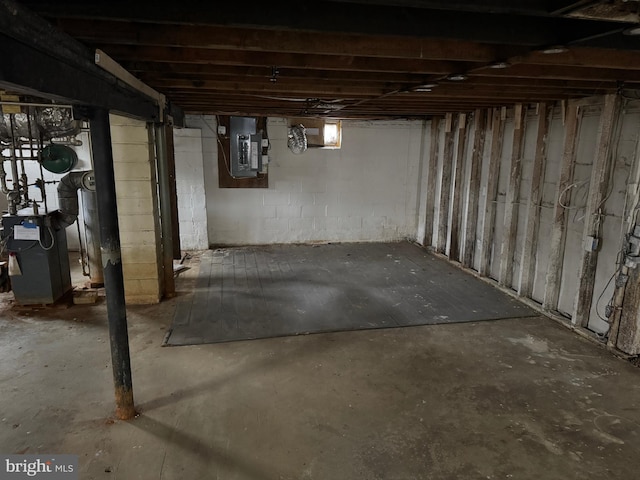 basement with electric panel and a heating unit