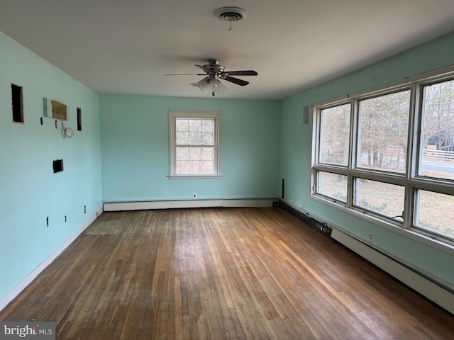 unfurnished room featuring a baseboard radiator, wood-type flooring, visible vents, and a ceiling fan