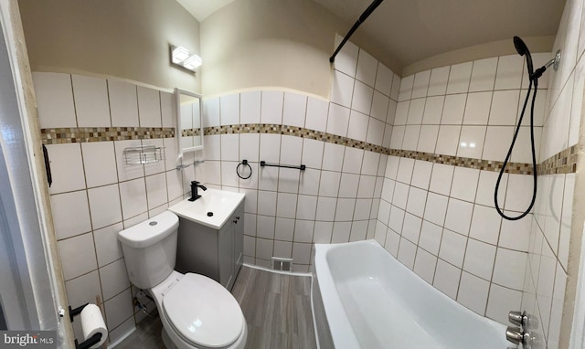 full bath with toilet, tile walls, bathtub / shower combination, and vanity