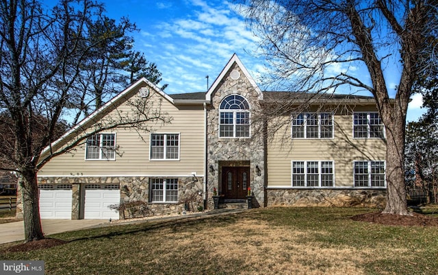 view of front facade featuring a garage, a front yard, concrete driveway, and stone siding