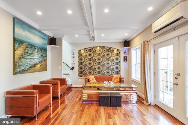 living area with an AC wall unit, wood finished floors, a healthy amount of sunlight, and coffered ceiling