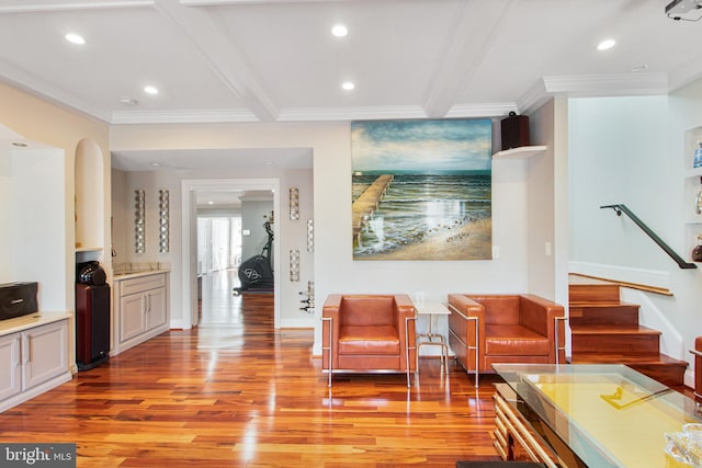 living area with stairway, beam ceiling, light wood-style floors, and crown molding