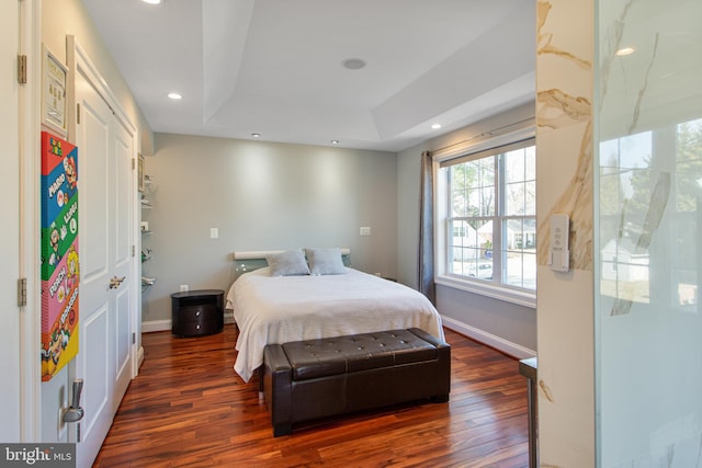 bedroom with recessed lighting, baseboards, a raised ceiling, and wood-type flooring