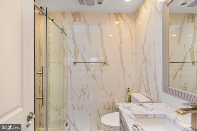 full bath with a marble finish shower, toilet, tile walls, and vanity