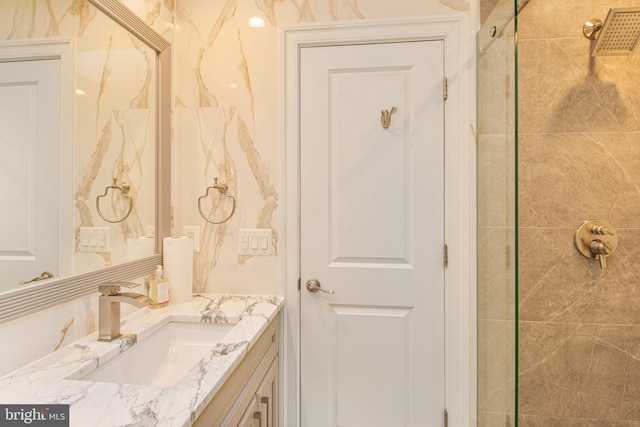 full bathroom featuring a tile shower and vanity