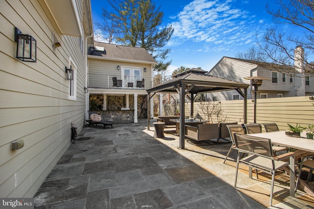 view of patio with a gazebo, outdoor dining space, an outdoor hangout area, and fence