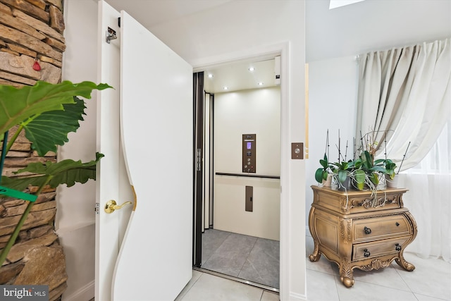 hall with tile patterned floors