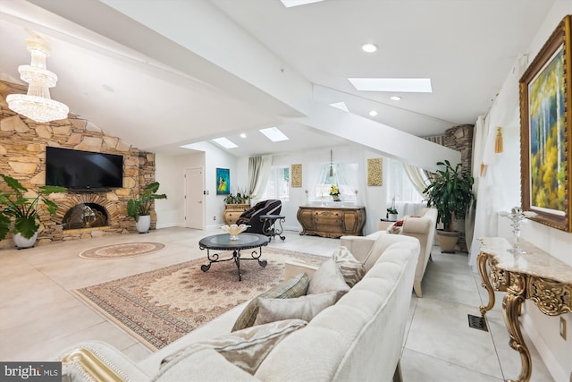 living area with recessed lighting, lofted ceiling with skylight, and a stone fireplace