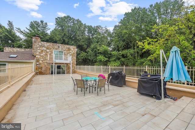 view of patio / terrace featuring grilling area, outdoor dining area, and fence