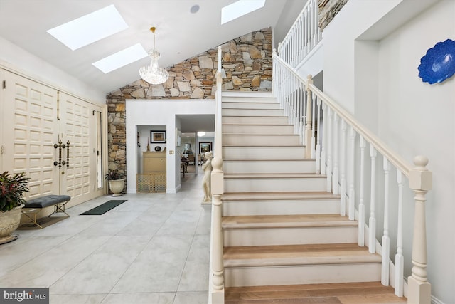 stairway featuring high vaulted ceiling and a skylight