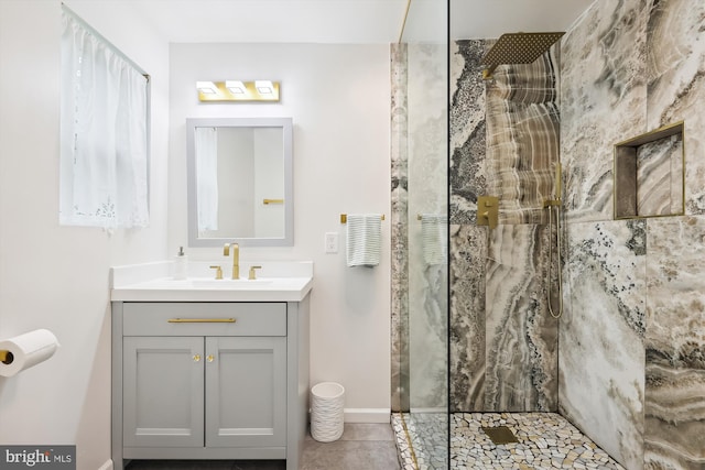 bathroom with tile patterned flooring, baseboards, vanity, and a walk in shower