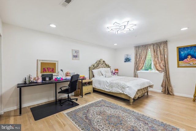 bedroom with recessed lighting, visible vents, baseboards, and wood finished floors