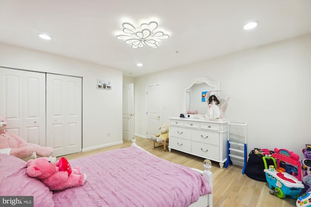 bedroom with recessed lighting, light wood-type flooring, baseboards, and a closet