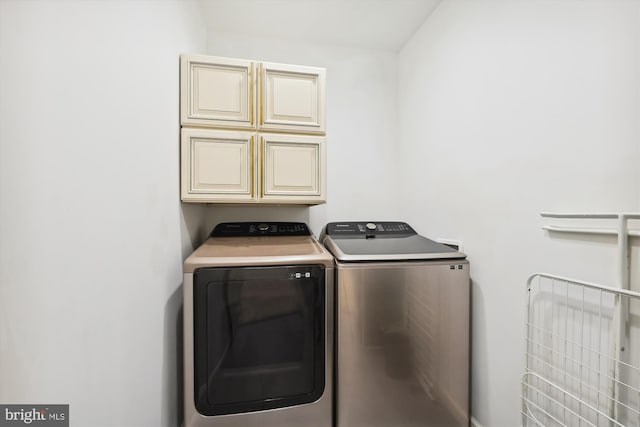 washroom with cabinet space and independent washer and dryer