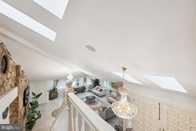 living room featuring light tile patterned flooring and vaulted ceiling with skylight