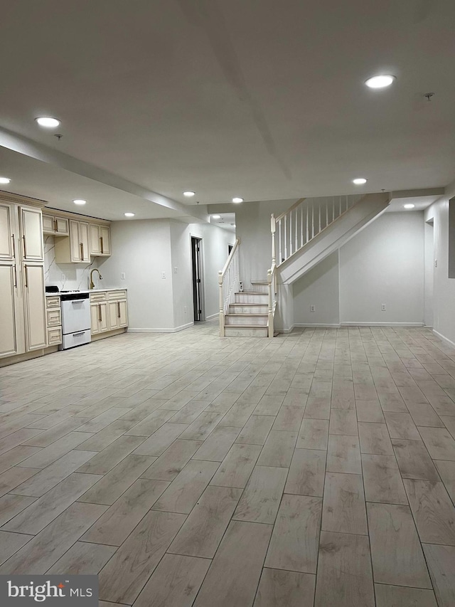 basement featuring recessed lighting, baseboards, light wood-style flooring, and stairs