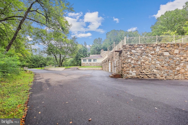 view of road featuring stairway and driveway