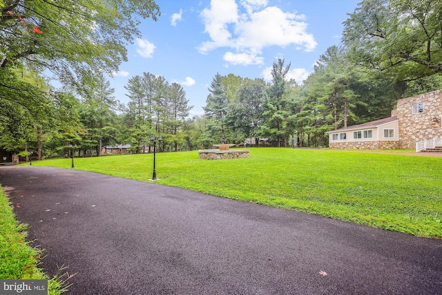 exterior space featuring aphalt driveway and a lawn