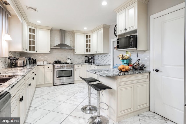 kitchen with visible vents, marble finish floor, stainless steel appliances, wall chimney range hood, and light stone countertops