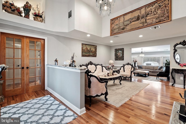 foyer entrance with visible vents, a chandelier, and french doors