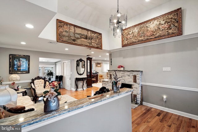 kitchen featuring stone countertops, wood finished floors, recessed lighting, crown molding, and baseboards