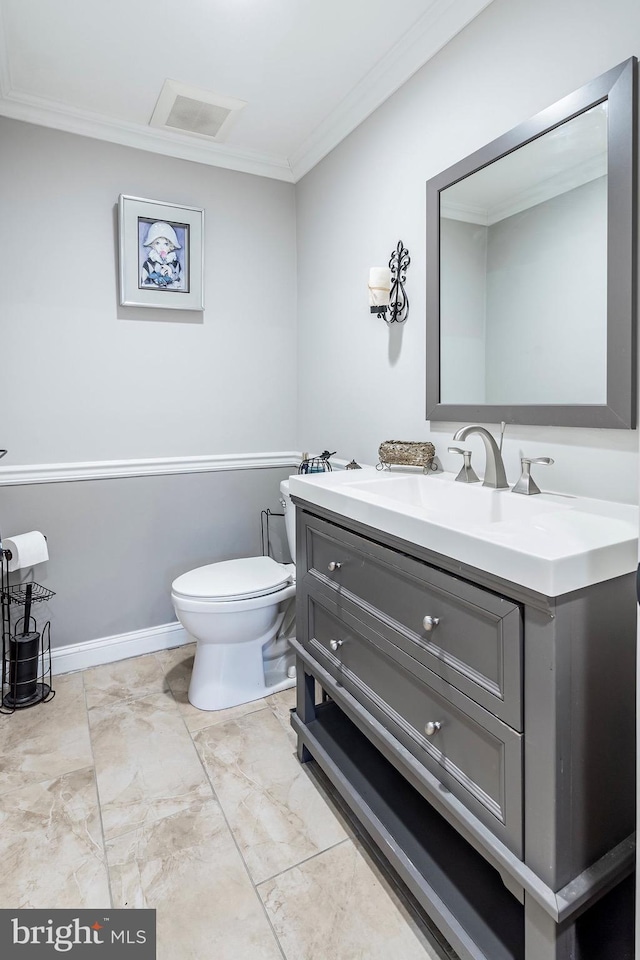 bathroom featuring vanity, baseboards, visible vents, ornamental molding, and toilet