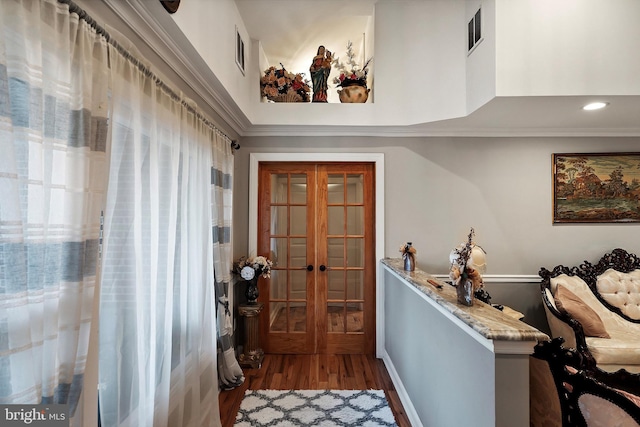 interior space featuring french doors, a high ceiling, visible vents, and wood finished floors