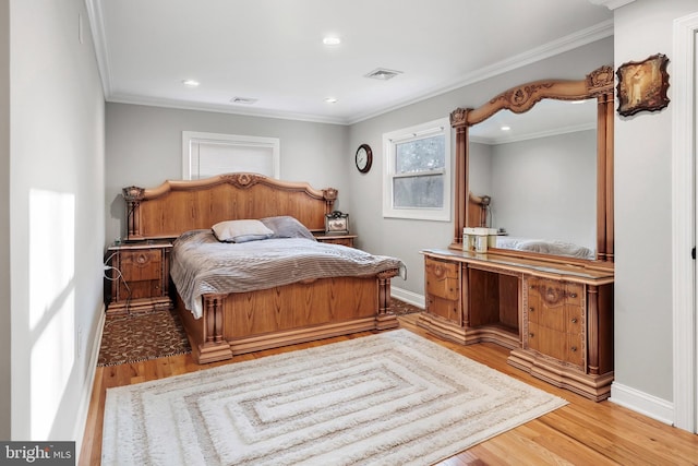 bedroom with light wood-style flooring, crown molding, and baseboards