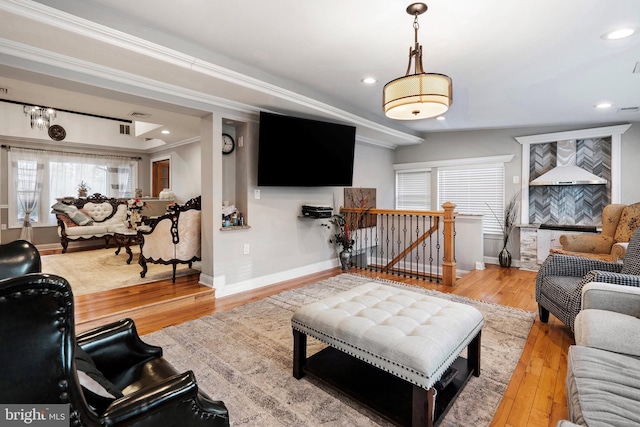 living room featuring recessed lighting, baseboards, ornamental molding, and hardwood / wood-style flooring