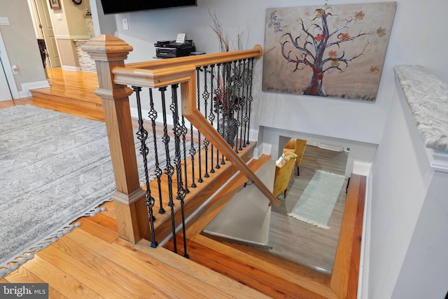 stairs with baseboards and wood finished floors