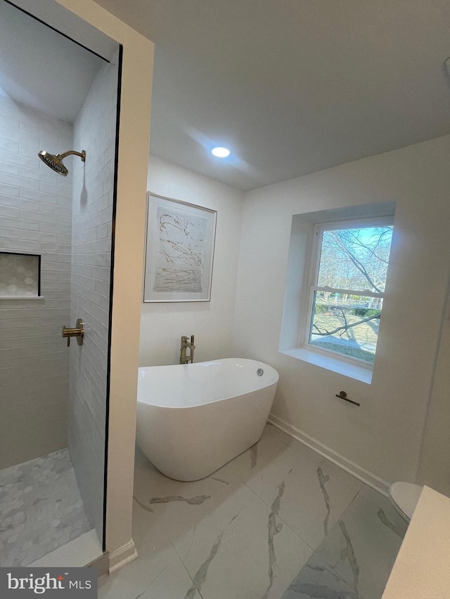 bathroom with baseboards, tiled shower, a soaking tub, and marble finish floor