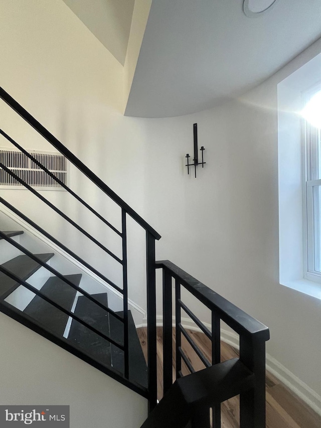 stairway with baseboards and wood finished floors