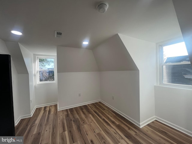 additional living space featuring visible vents, baseboards, vaulted ceiling, recessed lighting, and wood finished floors