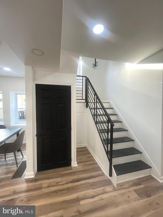 staircase with visible vents, recessed lighting, wood finished floors, and baseboards